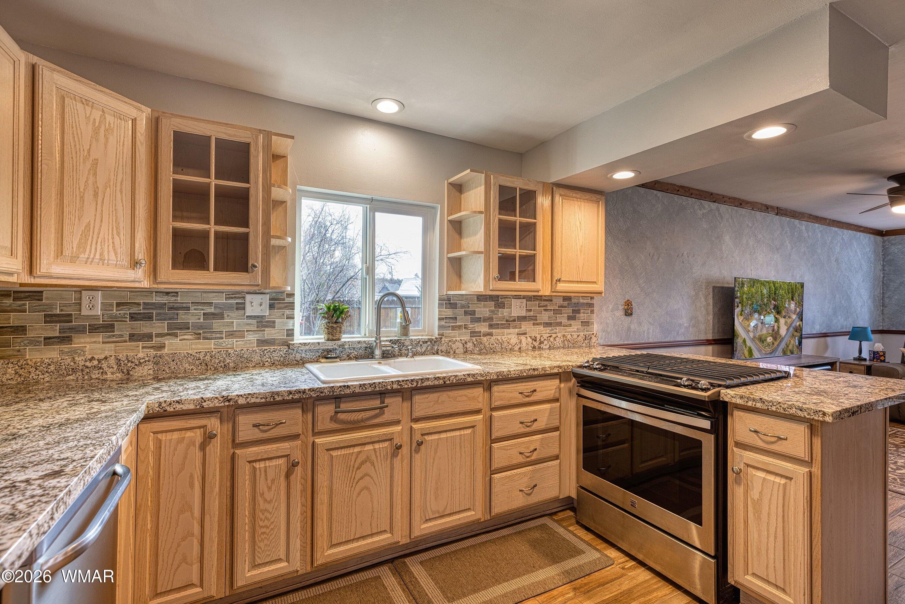 1306 West Pima Lane Lakeside, AZ 85929 - Photo 12 of 31 a kitchen with granite countertop stainless steel appliances a stove sink and cabinets