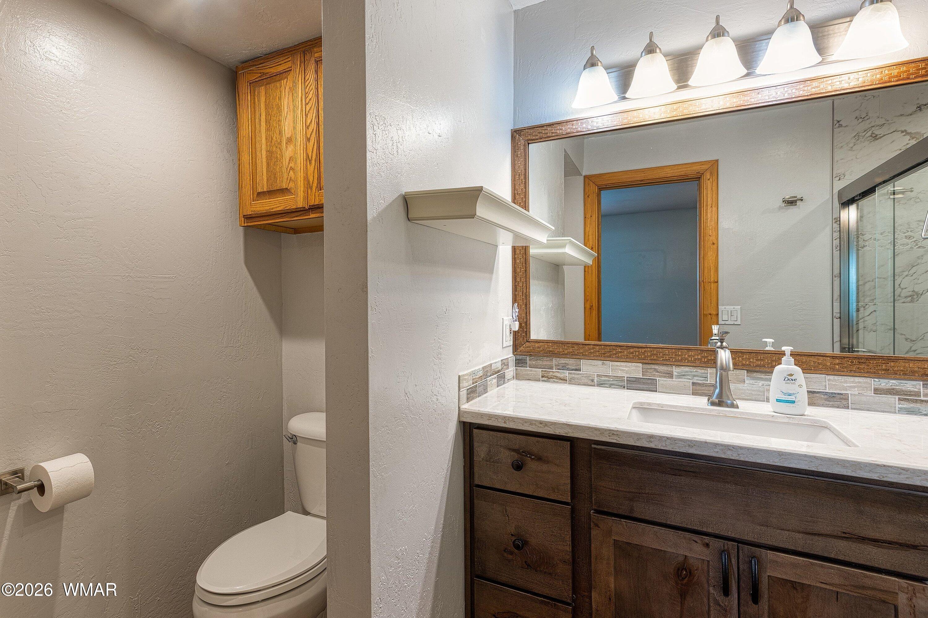 1306 West Pima Lane Lakeside, AZ 85929 - Photo 15 of 31 a bathroom with a granite countertop sink vanity mirror and toilet