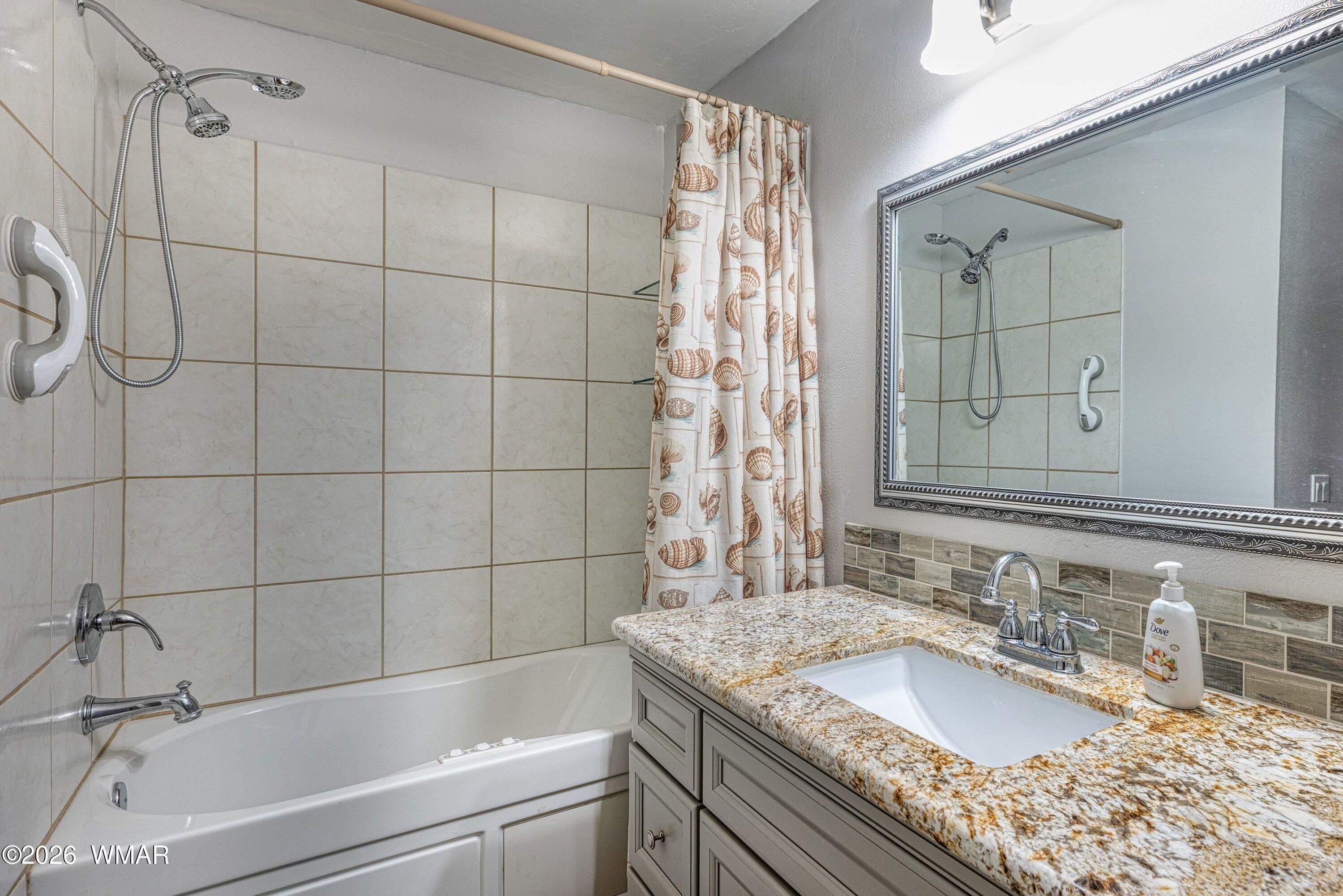 1306 West Pima Lane Lakeside, AZ 85929 - Photo 17 of 31 a bathroom with a granite countertop sink and a bathtub