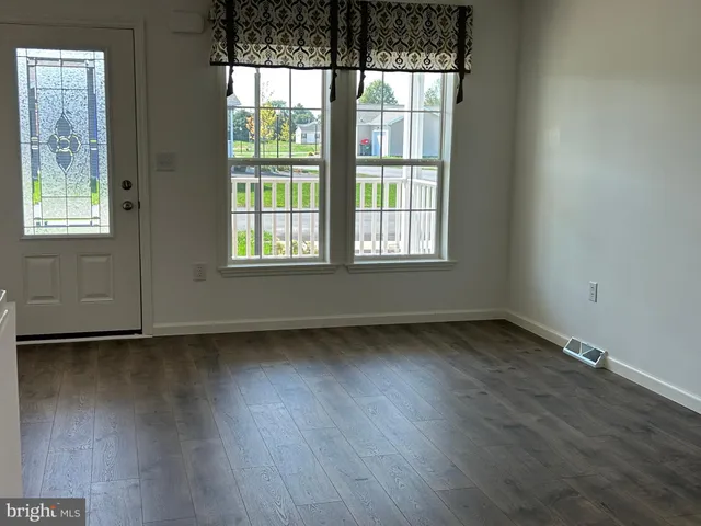 a kitchen with stainless steel appliances granite countertop a refrigerator a sink a stove a microwave and wooden floor