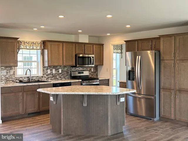 a kitchen with sink a microwave a stove and cabinets