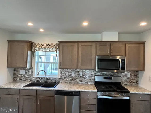a metallic refrigerator freezer sitting in a kitchen