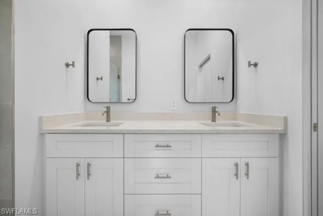 a bathroom with double vanity sinks and a mirror