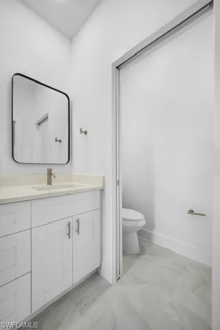 a bathroom with a toilet a sink and mirror