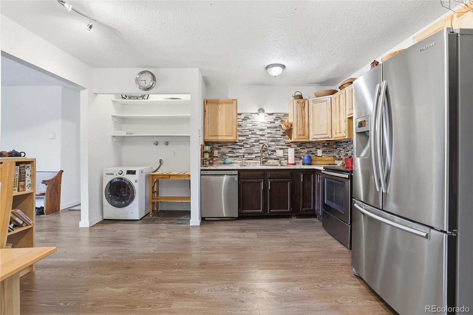 9225 Sandy Lane Conifer, CO 80433 - Photo 6 of 45 a kitchen with stainless steel appliances a refrigerator and wooden floor
