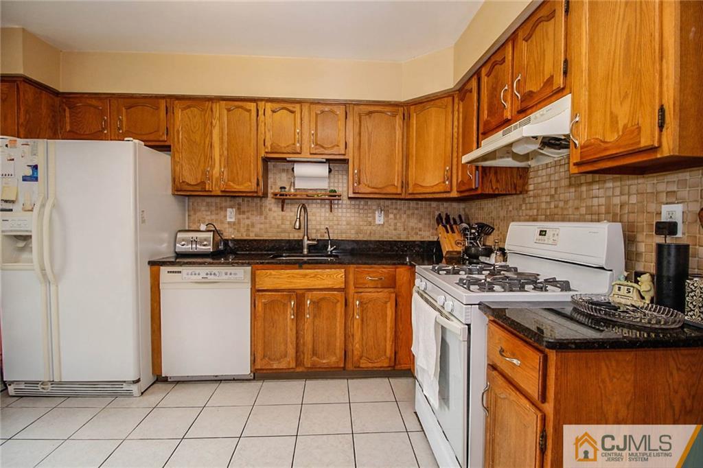 601 Maplecrest Road, Unit 601 Edison, NJ 08820 - Photo 11 of 25 a kitchen with stainless steel appliances granite countertop a refrigerator a stove a sink and a white cabinets