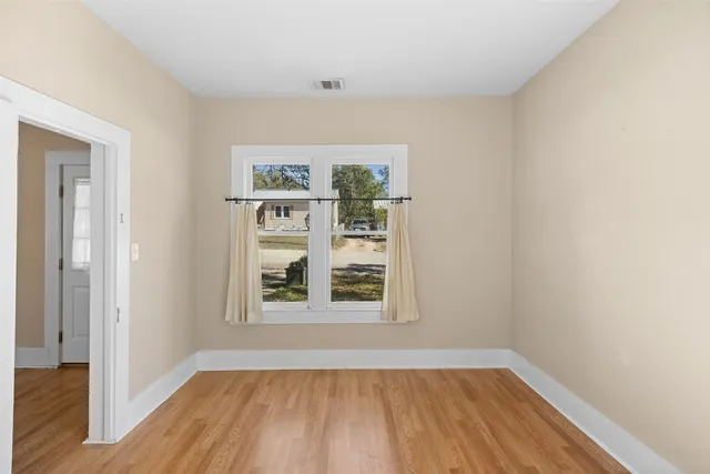 wooden floor in an empty room with a window