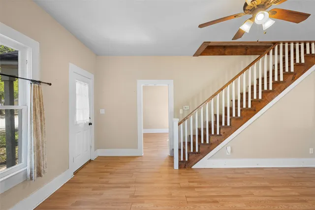 a view of staircase with lots of frames on wall and wooden floor