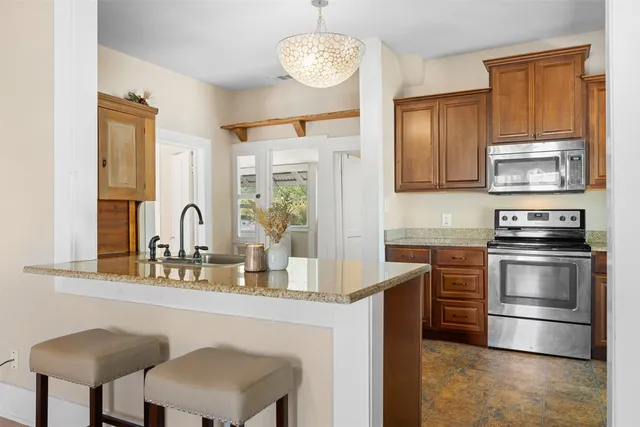 a kitchen with stainless steel appliances granite countertop a stove refrigerator sink and cabinets