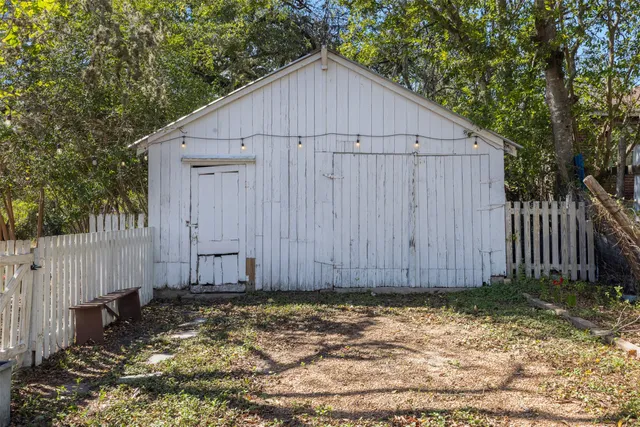 a view of a small house with yard and trees in the background