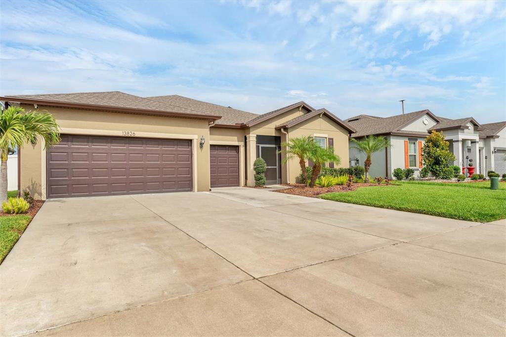 Welcome Home!  Tropical landscaping and luscious grass add to the beauty of this home.  Notice the covered, screened front entry for added privacy and security.