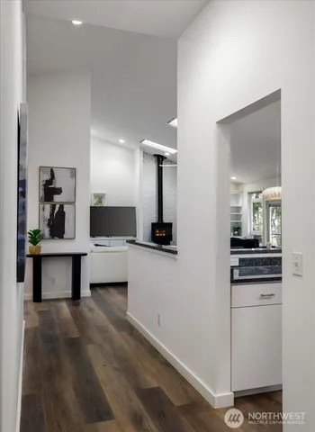 a living room with stainless steel appliances kitchen island granite countertop furniture and a fireplace