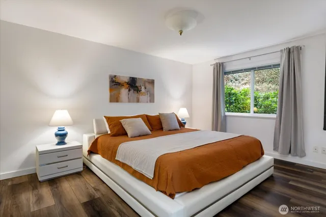 a large bed sitting in a bedroom next to a window