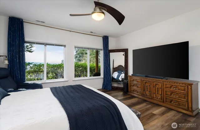 a bedroom with a bed and a flat tv screen on dresser