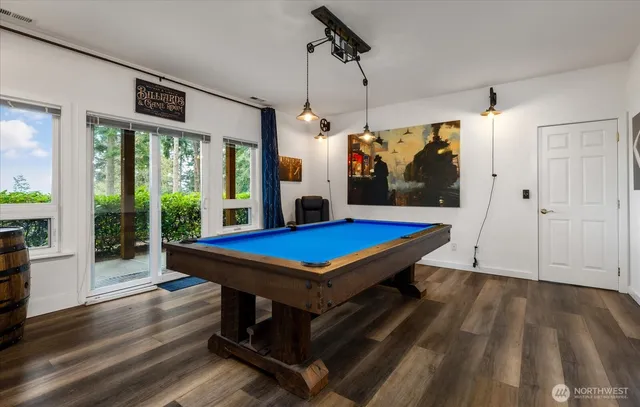 a room with pool table and windows