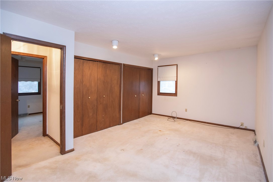 5985 Case Road North Ridgeville, OH 44039 - Photo 22 of 28 Unfurnished bedroom featuring a closet, multiple windows, and light carpet