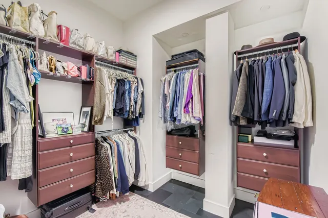 a view of walk in closet with clothes and shoes