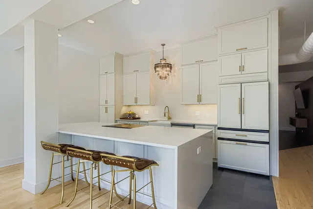 a kitchen with a sink a stove a refrigerator and white cabinets