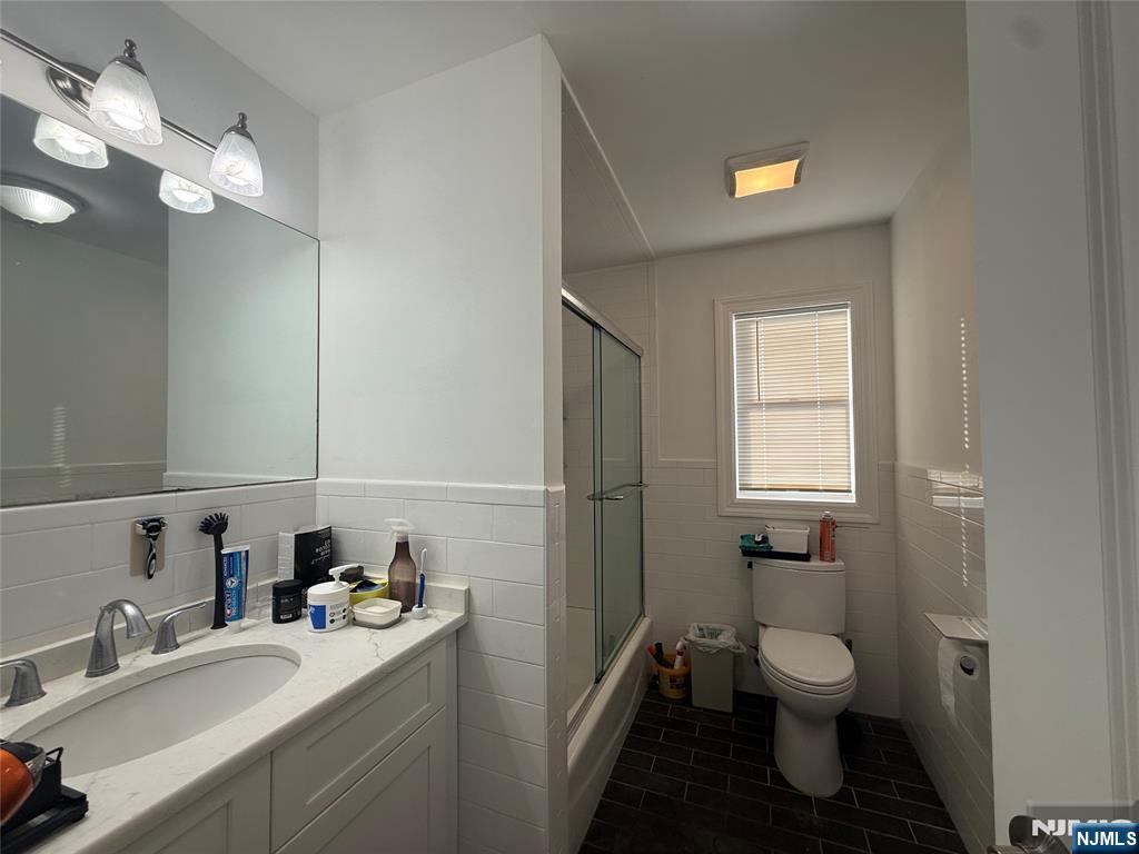 43 Jackson Avenue, Unit 1 Hackensack, NJ 07601 - Photo 10 of 14 a bathroom with a toilet sink and mirror