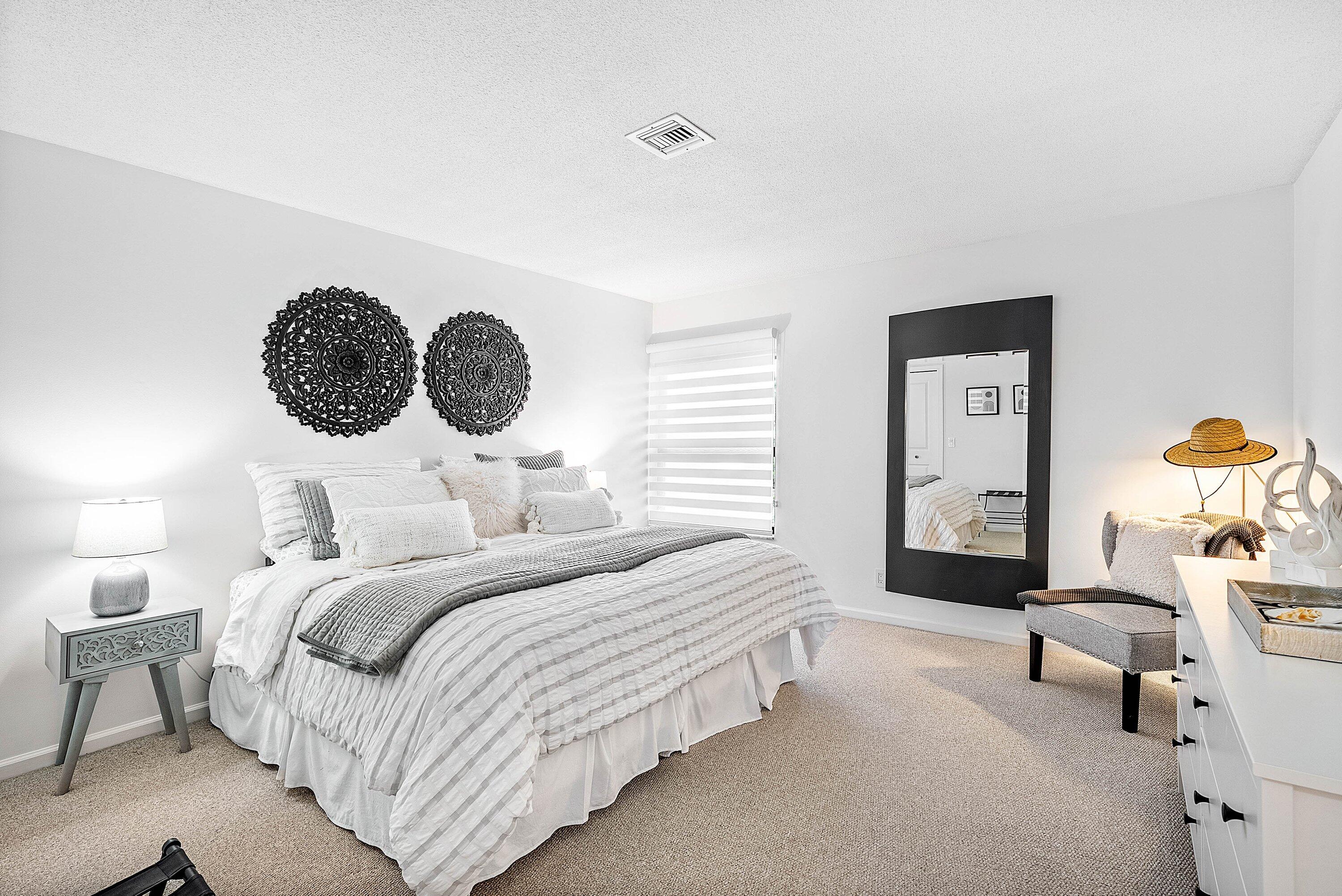 11126 Quail Covey Road, Unit MOCKINGBIRD Boynton Beach, FL 33436 - Photo 28 of 58 a bedroom with a bed and a chandelier