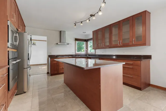 a kitchen with stainless steel appliances granite countertop a sink and a refrigerator