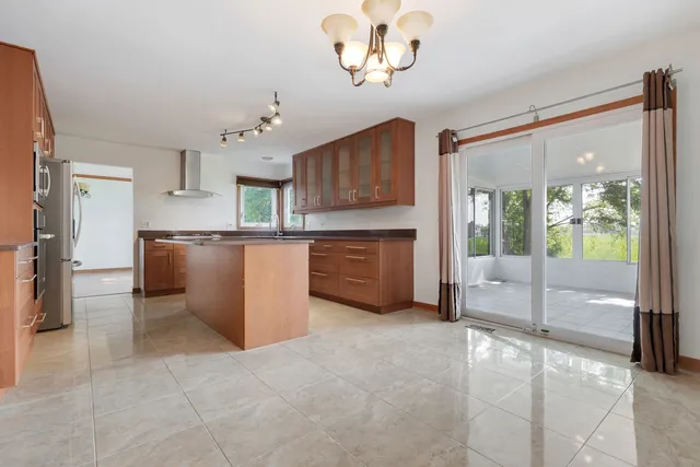an empty room with a cabinet and chandelier