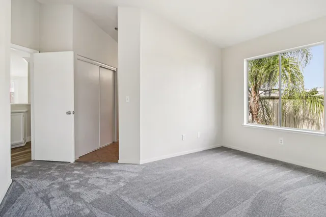 an empty room with windows and closet