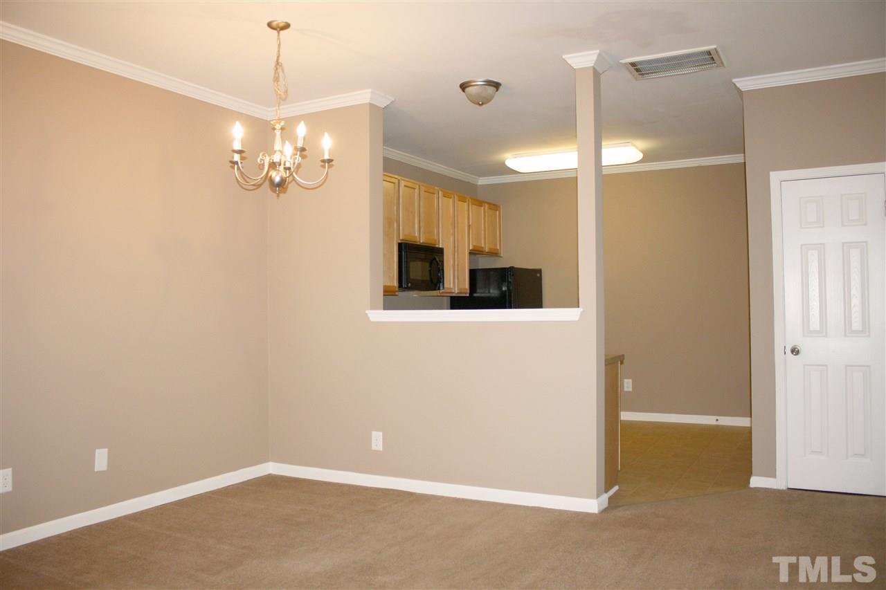 11720 Mezzanine Drive, Unit 103 Raleigh, NC 27614 - Photo 6 of 21 a view of a livingroom with a kitchen and a chandelier fan