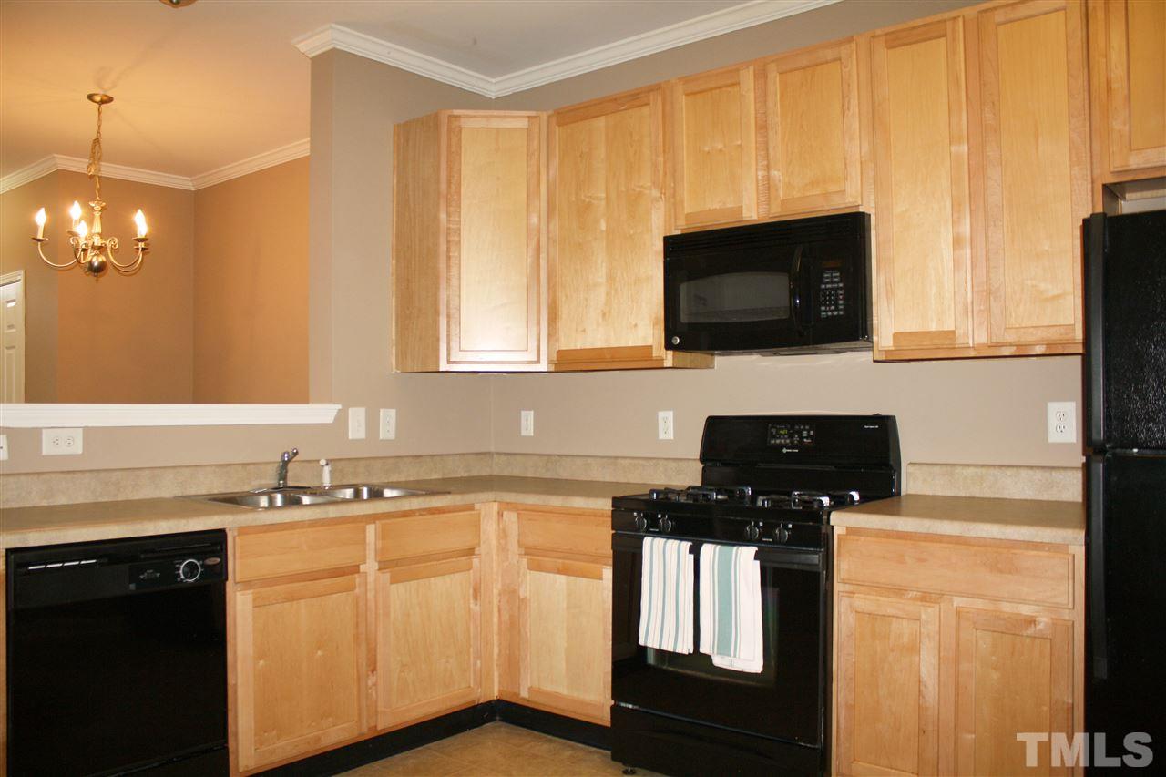 11720 Mezzanine Drive, Unit 103 Raleigh, NC 27614 - Photo 7 of 21 a kitchen with stainless steel appliances a stove sink microwave and cabinets