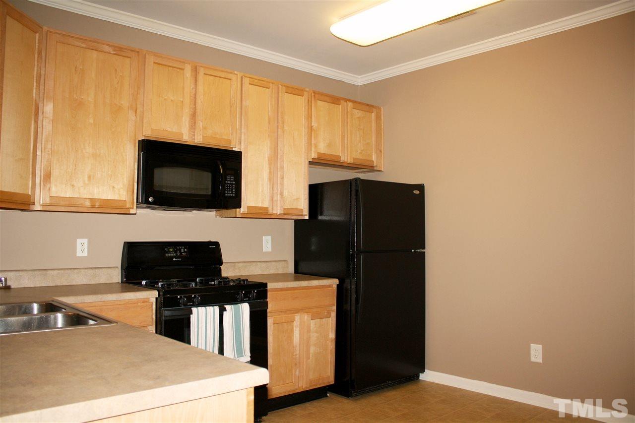 11720 Mezzanine Drive, Unit 103 Raleigh, NC 27614 - Photo 8 of 21 a kitchen with a refrigerator and a stove top oven