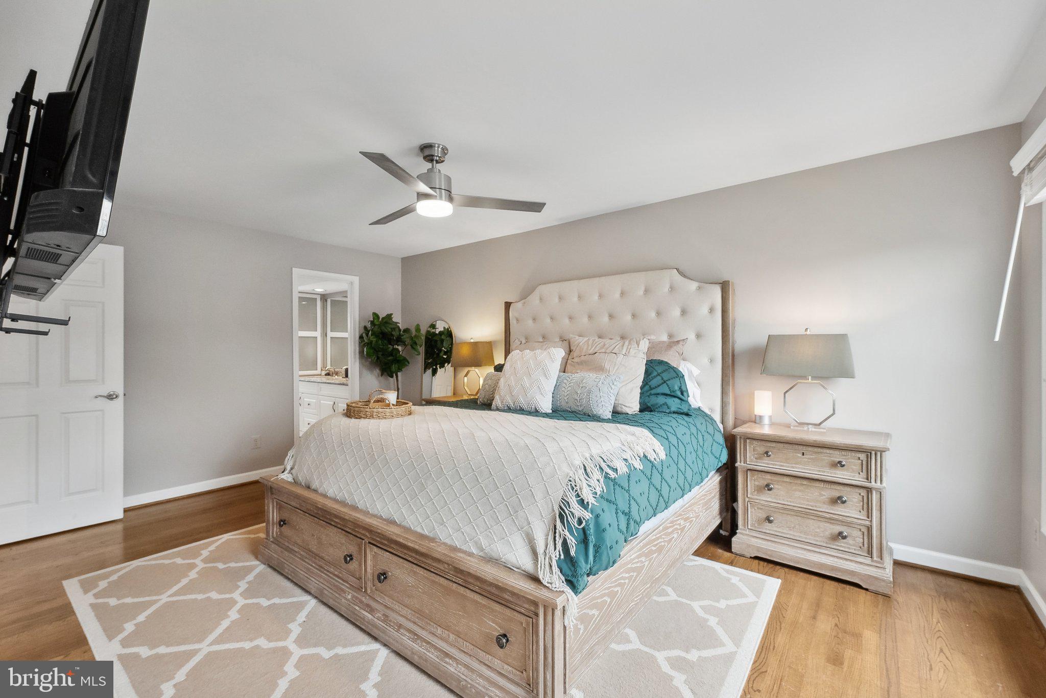 7940 Donegal Lane Springfield, VA 22153 - Photo 16 of 36 a bedroom with a bed a mirror on dresser and a wooden floor