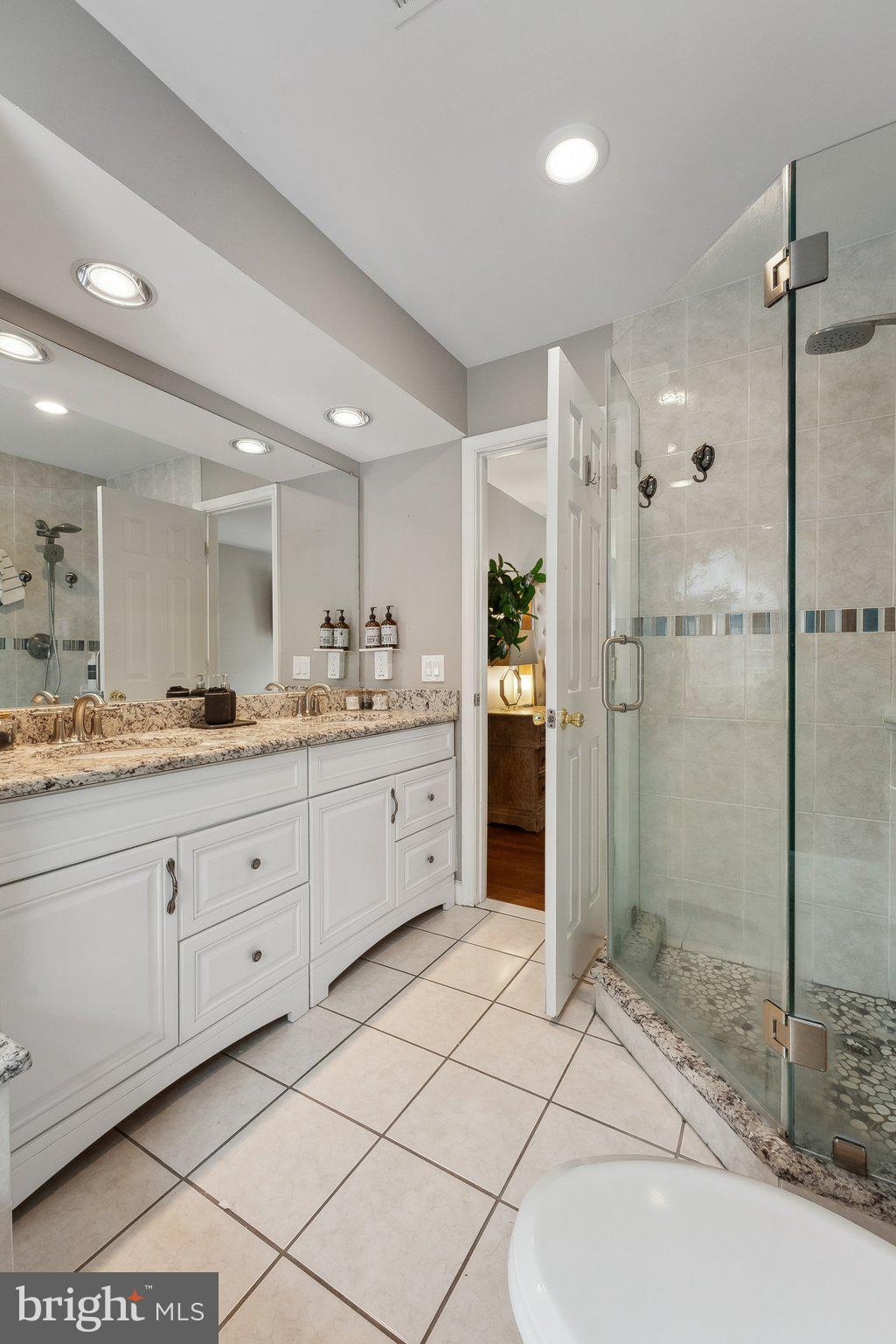 7940 Donegal Lane Springfield, VA 22153 - Photo 19 of 36 a spacious bathroom with a shower a sink and a mirror