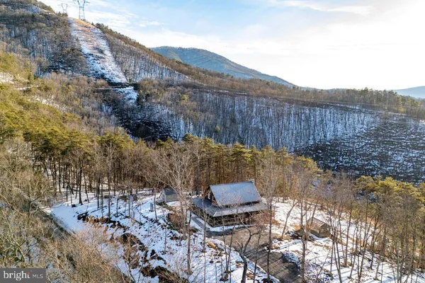 a front view of a house with a yard and mountain view