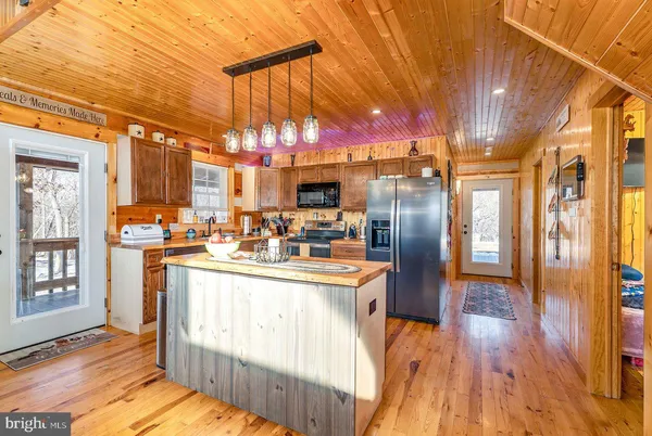 a kitchen with stainless steel appliances granite countertop a sink a stove and a refrigerator
