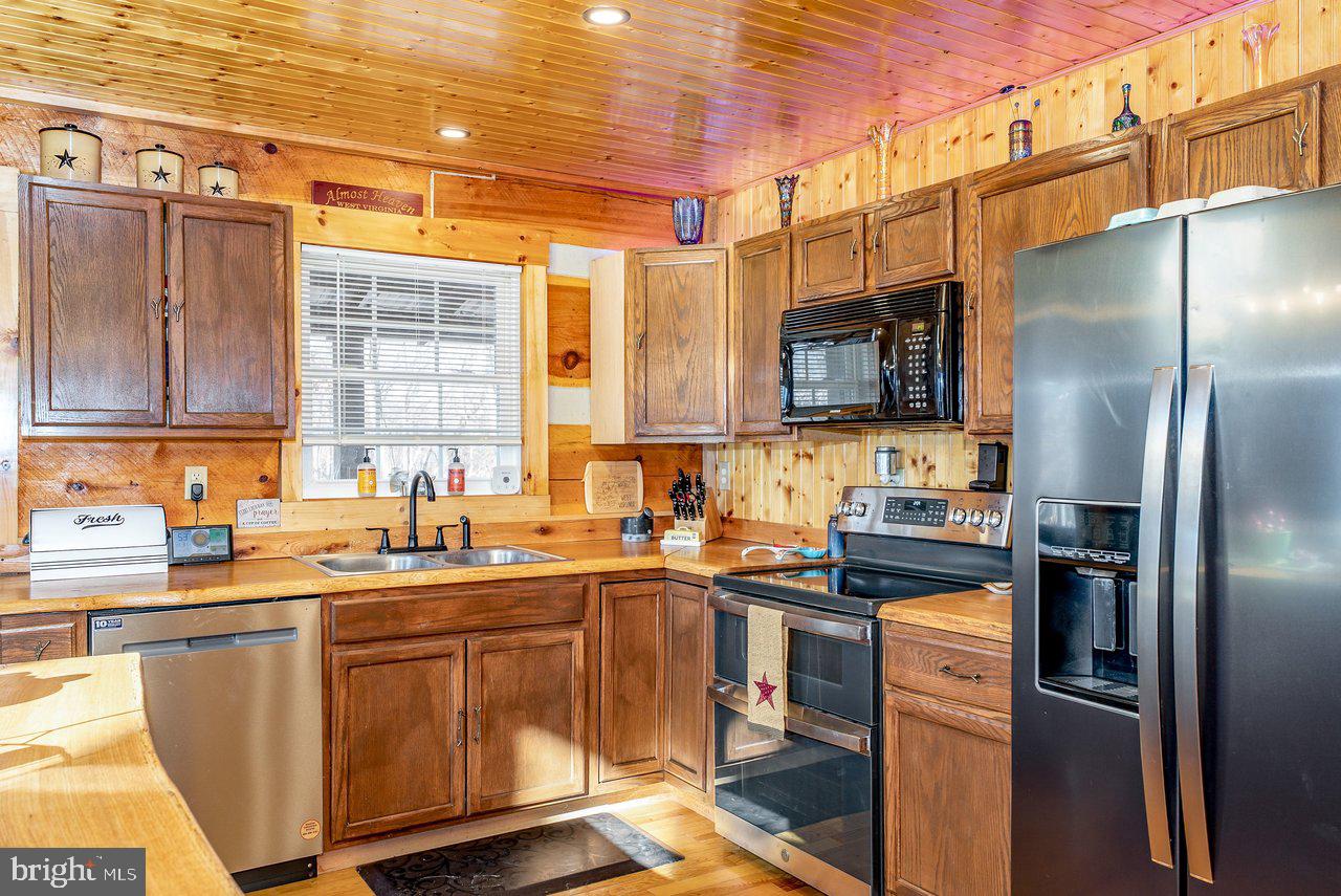 147 Bear Rdg Lane Milam, WV 26838 - Photo 9 of 72 a kitchen with stainless steel appliances a sink a stove a refrigerator cabinets and a counter top space