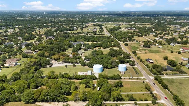 an aerial view of residential houses with outdoor space and trees