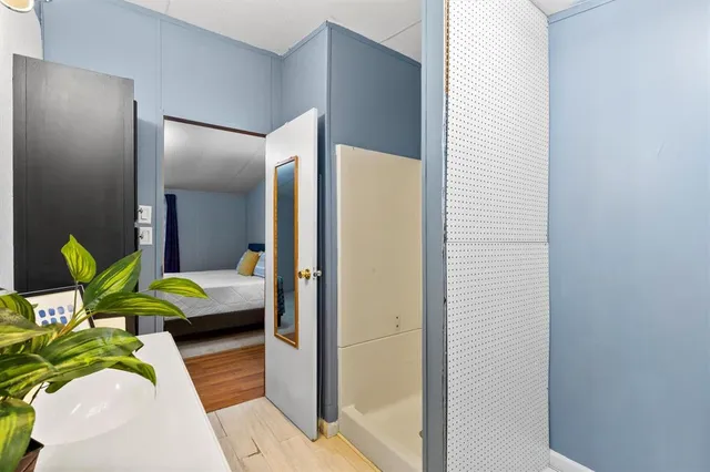 a bedroom with a bed and wooden floor