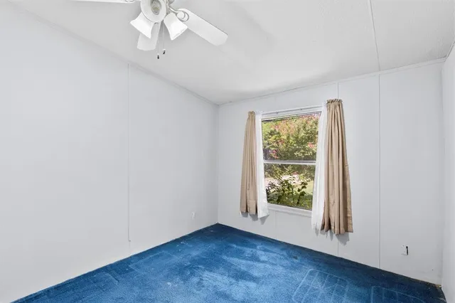 a spacious bedroom with a bed and a lamp