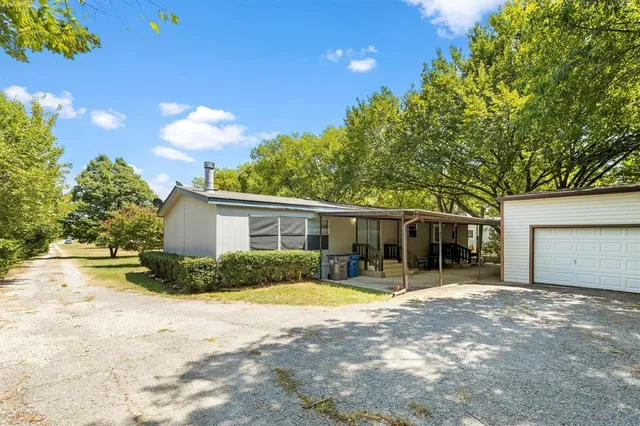 a view of a house with a yard and potted plants