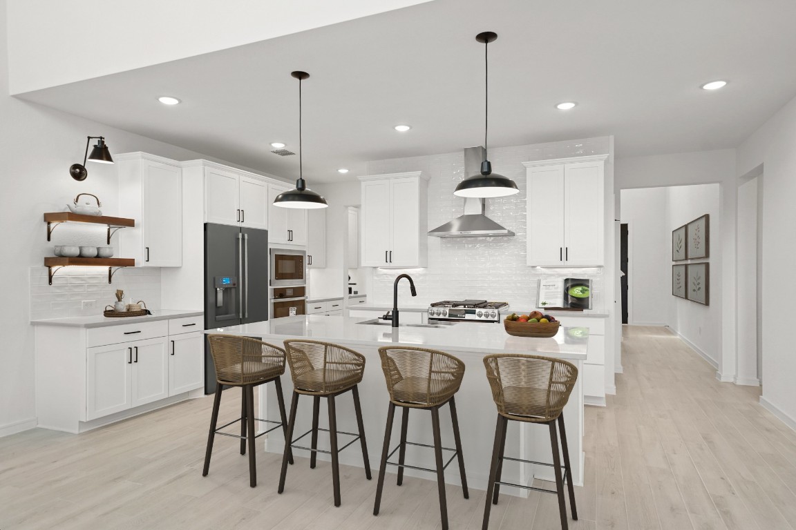 2826 Clapbread Lane Rosenberg, TX 77471 - Photo 5 of 41 a kitchen with stainless steel appliances kitchen island granite countertop a dining table chairs and white cabinets