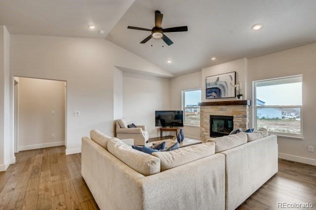 324 Spring Beauty Drive Berthoud, CO 80513 - Photo 6 of 25 a living room with furniture a fireplace and a flat screen tv