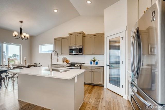 324 Spring Beauty Drive Berthoud, CO 80513 - Photo 8 of 25 a kitchen with stainless steel appliances granite countertop a refrigerator a sink a stove and white cabinets with wooden floor