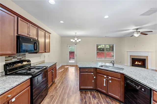 a kitchen with stainless steel appliances granite countertop a stove a sink and a microwave