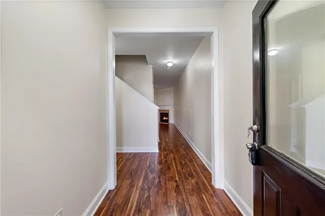 a view of a hallway with wooden floor and staircase