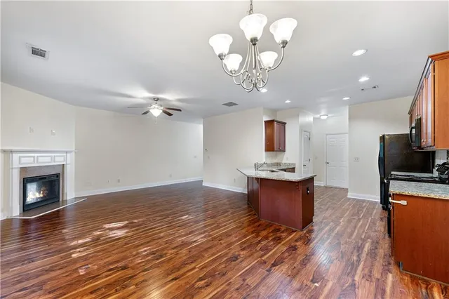 a view of a kitchen with a sink a refrigerator a fireplace and wooden floor