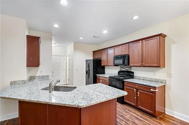 a kitchen with stainless steel appliances granite countertop a sink stove and refrigerator
