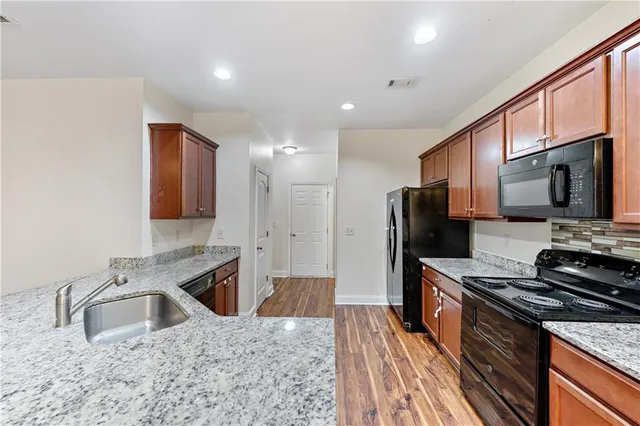 a kitchen with stainless steel appliances granite countertop a sink stove and refrigerator