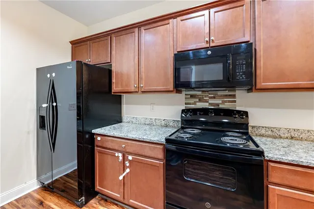 a kitchen with stainless steel appliances granite countertop a stove microwave and refrigerator