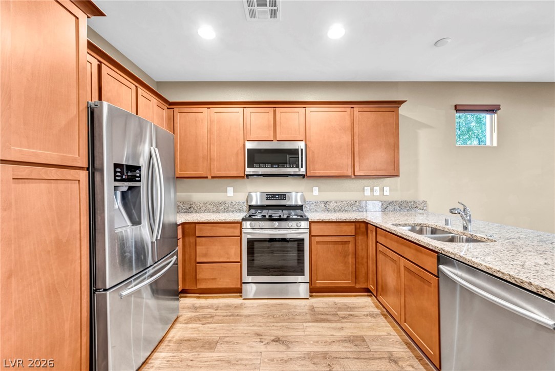 5014 Fiery Sky Ridge Street Las Vegas, NV 89148 - Photo 8 of 21 A well-equipped kitchen showcasing elegant granite countertops and modern stainless steel appliances.