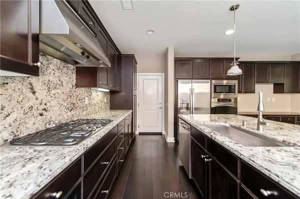 a kitchen with stainless steel appliances granite countertop a sink stove and refrigerator
